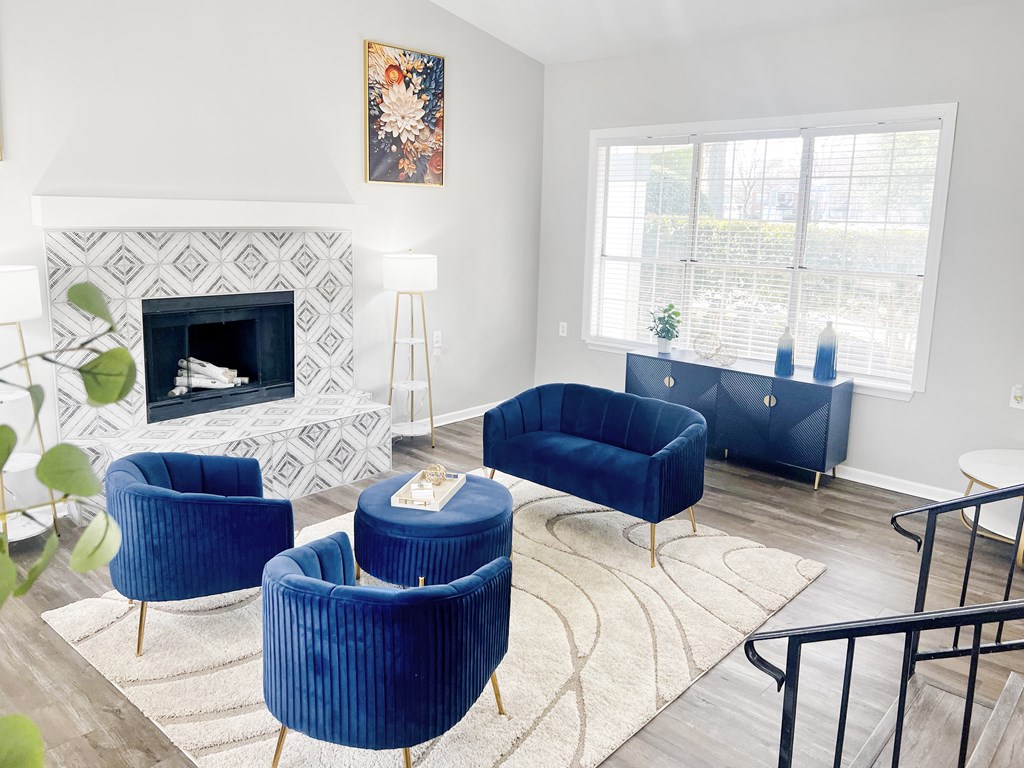 A living room with a fireplace and blue chairs.