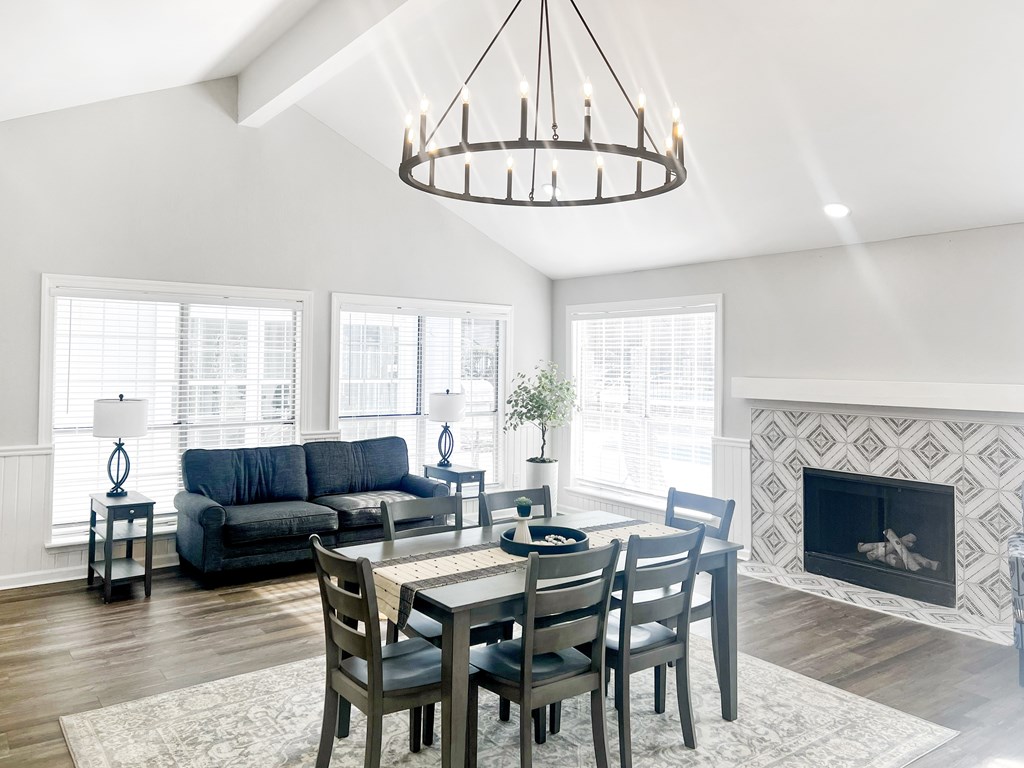 A modern dining room with a fireplace and a large window.