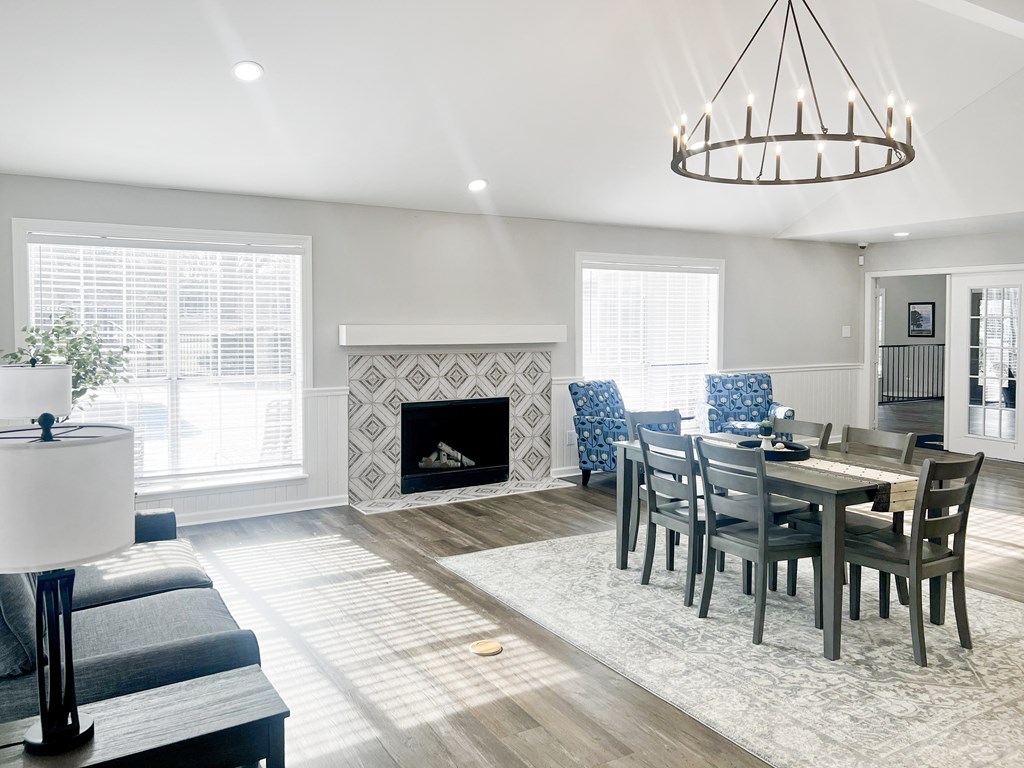 A modern living room with a fireplace and a dining table set up.