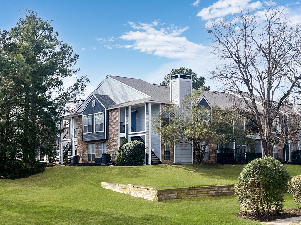 A large house with a grey roof and a white chimney.