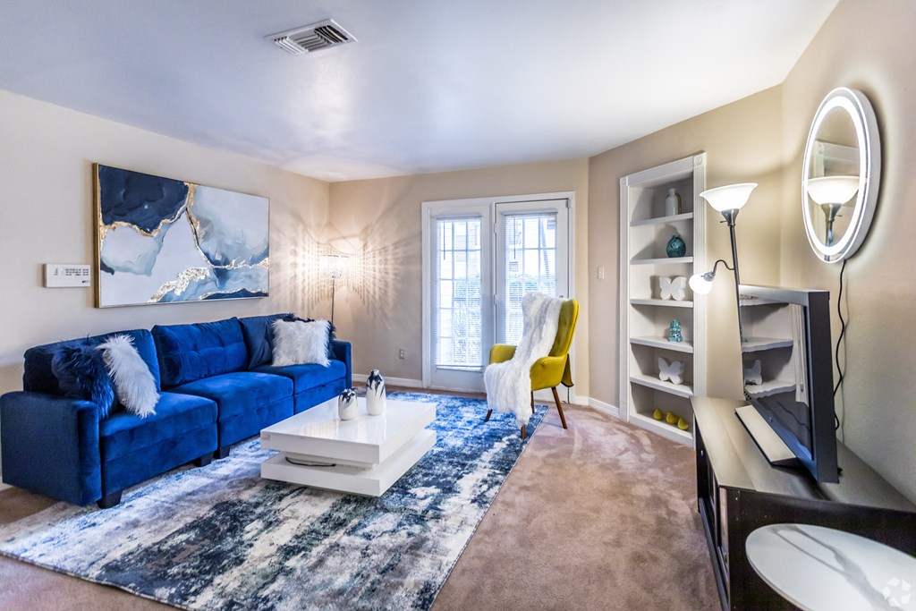 a living room with a blue couch and a white coffee table
