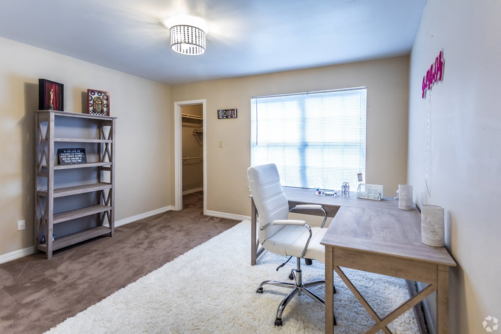 a home office with a desk and chair and a large window
