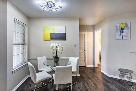 a dining room with a glass table and white chairs at The Trails at Mt. Moriah, Memphis, TN