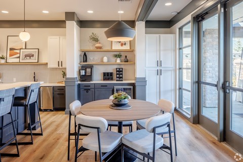 A modern kitchen with a dining table set for four.