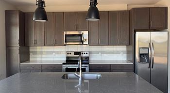 A modern kitchen with a stainless steel refrigerator and a central island at The Collective NoDa, Charlotte