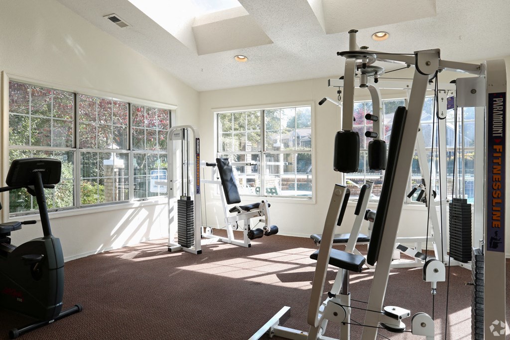 a gym with exercise equipment in a room with windows