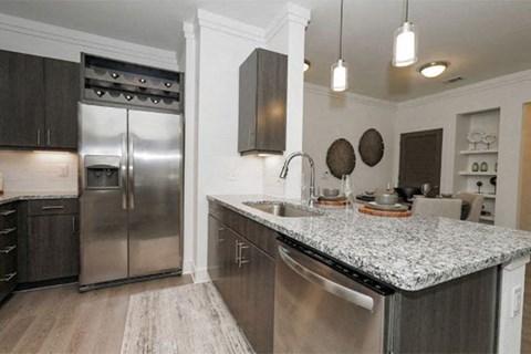 a kitchen with stainless steel appliances and a marble counter top