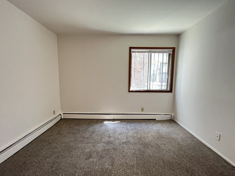 an empty room with a window and a carpet