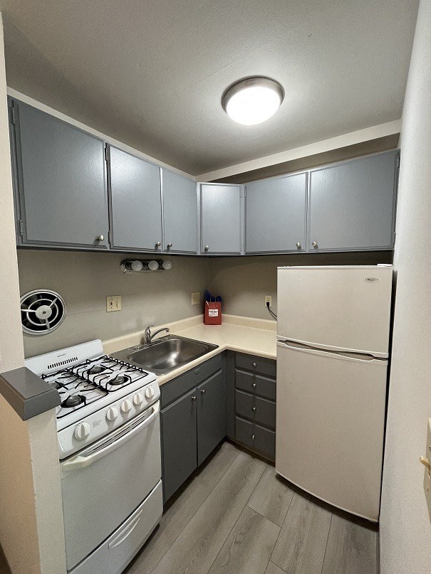 a kitchen with a stove refrigerator and a sink