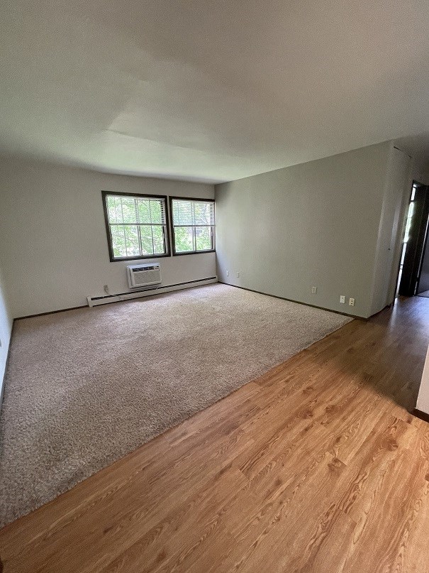 an empty living room with wooden floors and a window