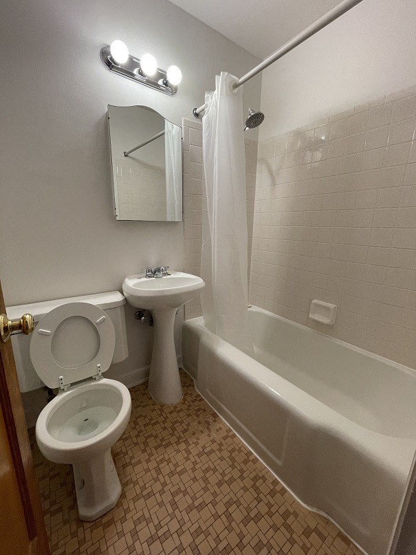 a bathroom with a toilet and a sink and a tub