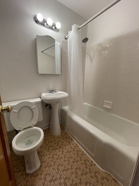 a bathroom with a toilet and a sink and a tub