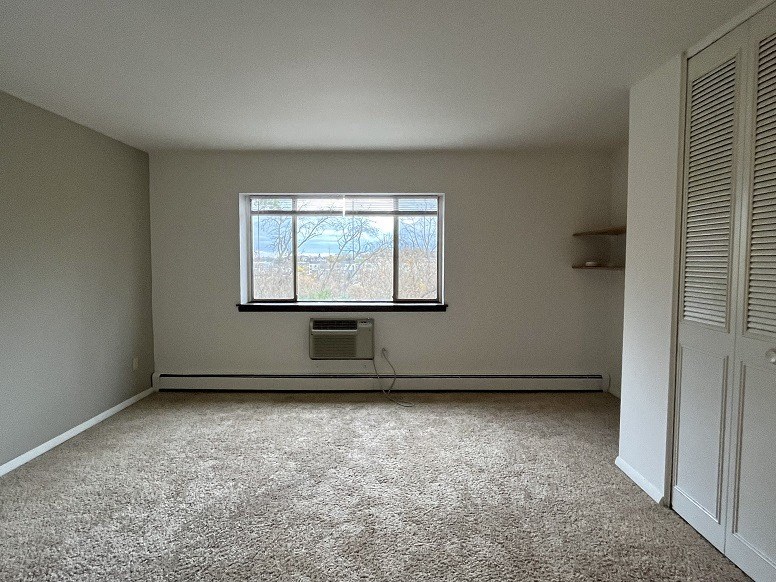 an empty room with a window and a closet