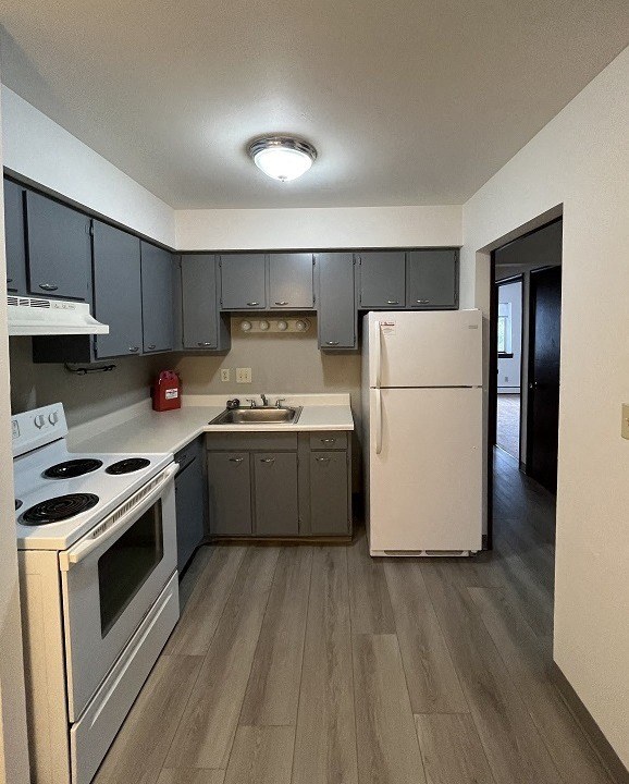 a kitchen with white appliances and gray cabinets