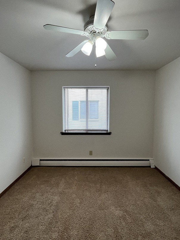 an empty room with a ceiling fan and a window