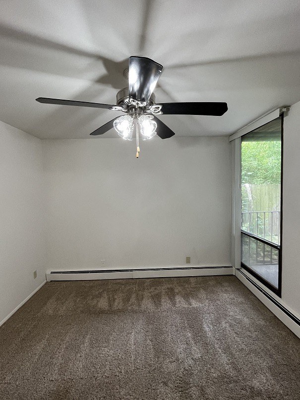 an empty living room with a ceiling fan and a window
