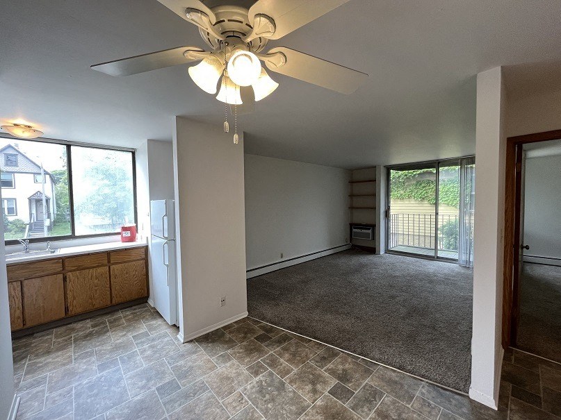an empty kitchen and living room with a ceiling fan
