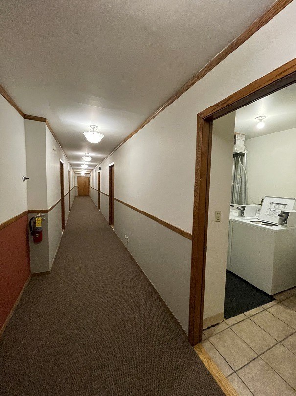 a hallway with a sink and a mirror in a room