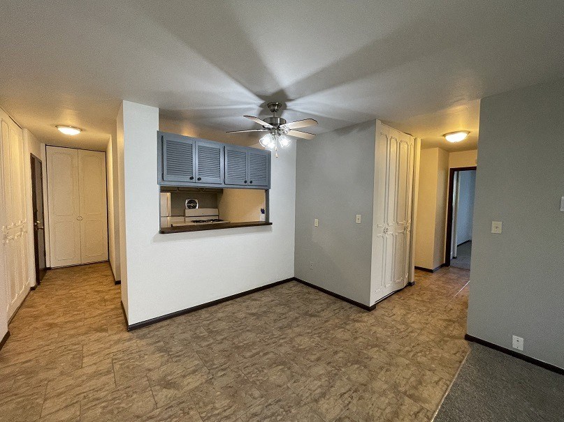 an empty living room with a ceiling fan