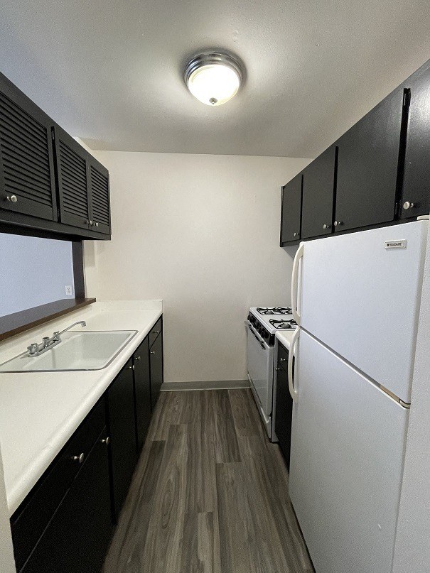 a kitchen with white appliances and black cabinets