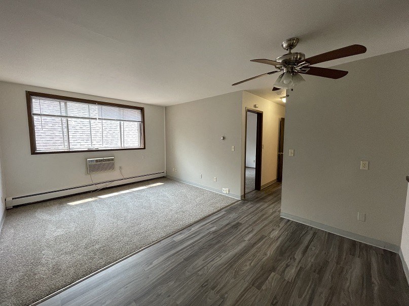 an empty bedroom with a ceiling fan