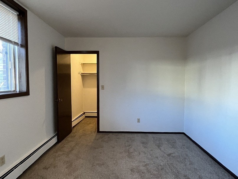 an empty room with white walls and a door to a closet