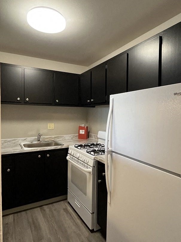 a kitchen with white appliances and black cabinets