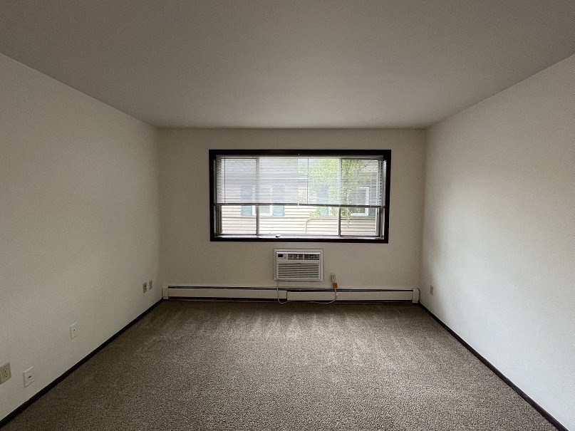 an empty room with a window and a radiator
