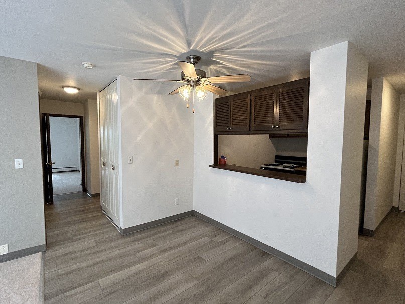 a living room with a ceiling fan and a kitchen