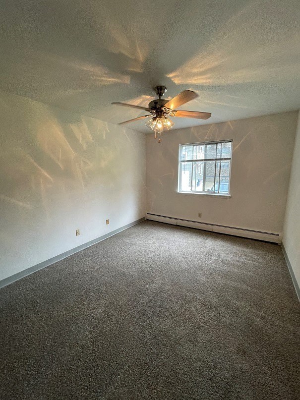 an empty room with a ceiling fan and a window