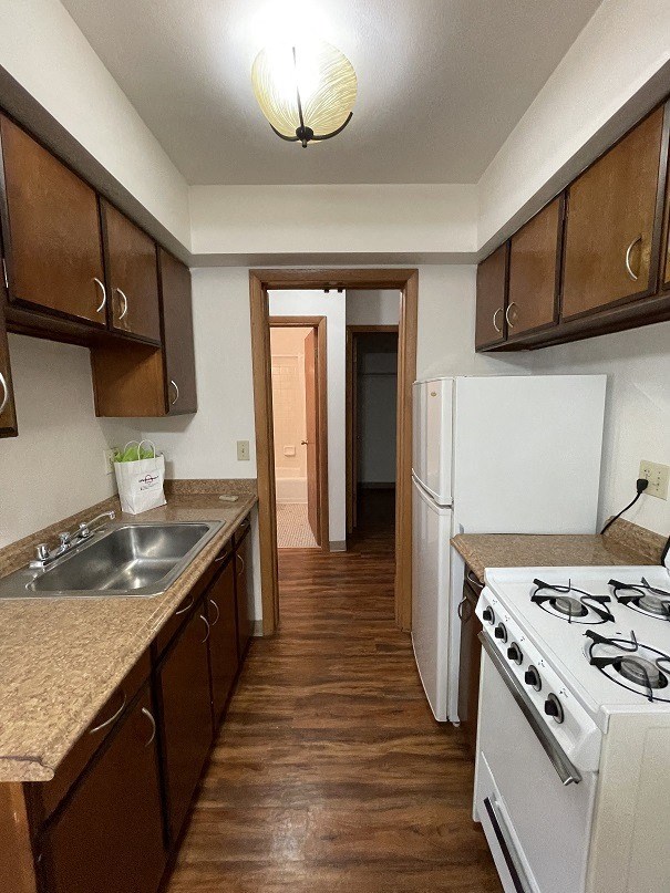 a kitchen with a stove and a sink and a refrigerator