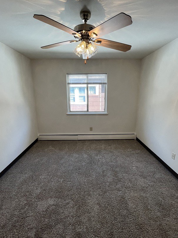 an empty room with a ceiling fan and a window