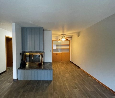 a living room with a fireplace and a ceiling fan
