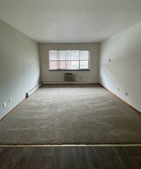an empty room with a window and a carpet