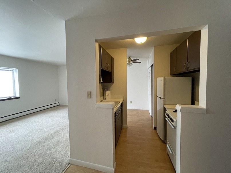 a view of a kitchen and a living room with a refrigerator and a stove