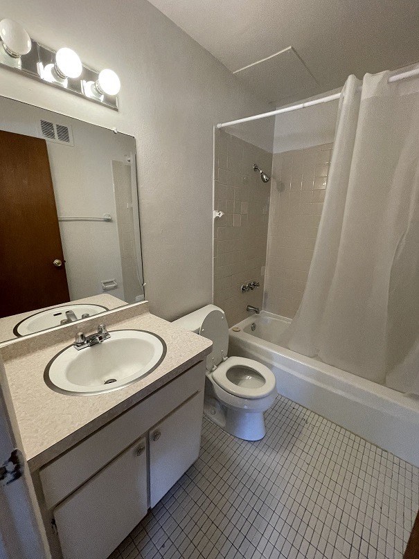 a bathroom with two toilets and a row of urinals