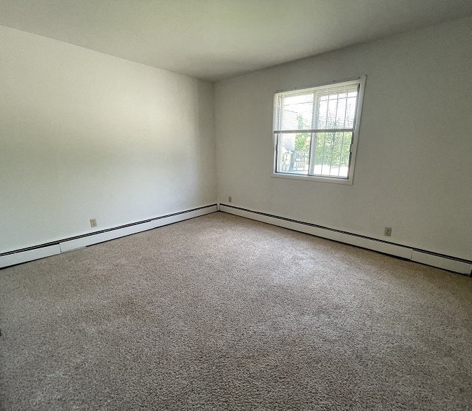 an empty room with a window and carpet
