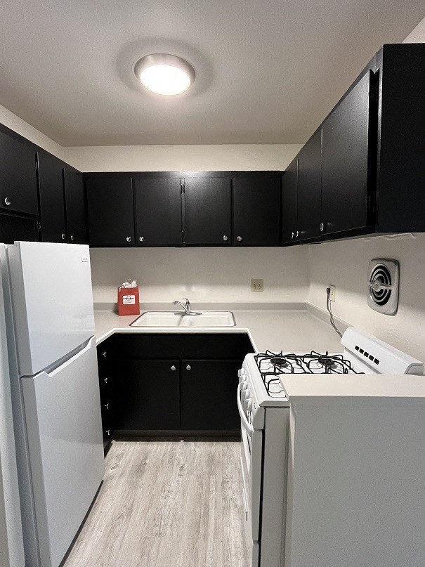 a kitchen with white appliances and black cabinets