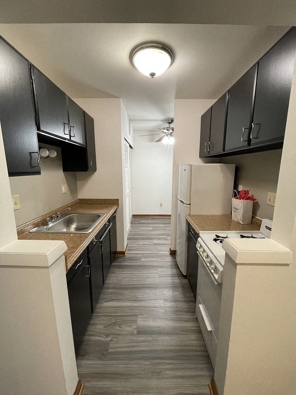 a kitchen with black cabinets and white appliances