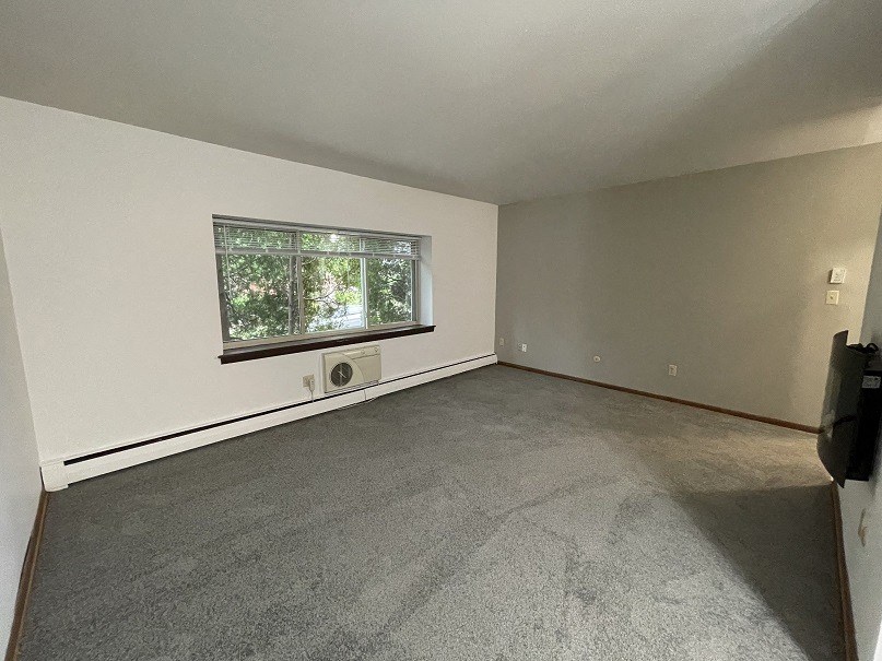 an empty bedroom with a large window