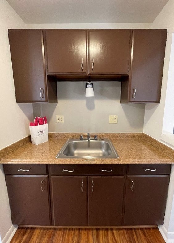 a kitchen with brown cabinets and a sink
