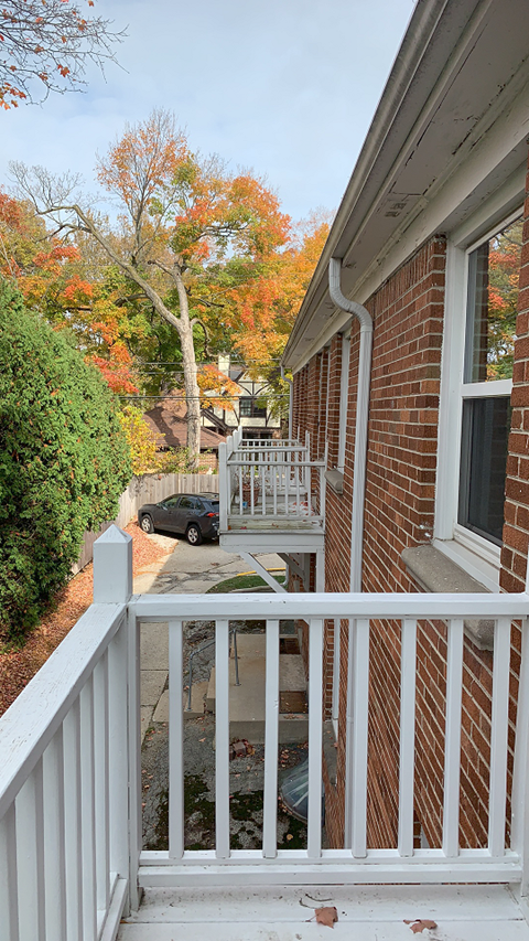 a porch with a car parked on the side of a house