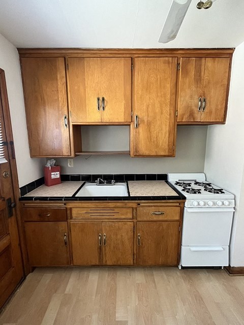 a kitchen with wooden cabinets and a stove and a sink