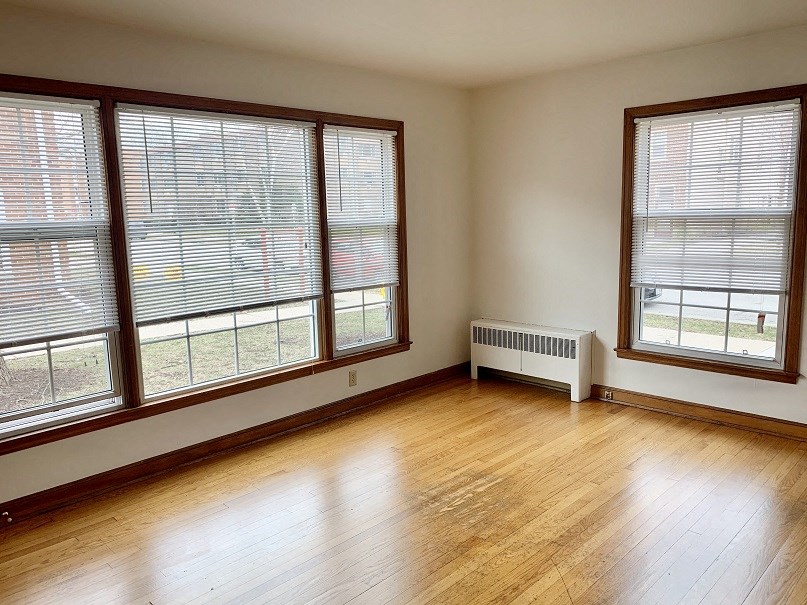 the living room of a house with wood floors and large windows