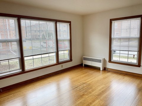 the living room of a house with wood floors and large windows