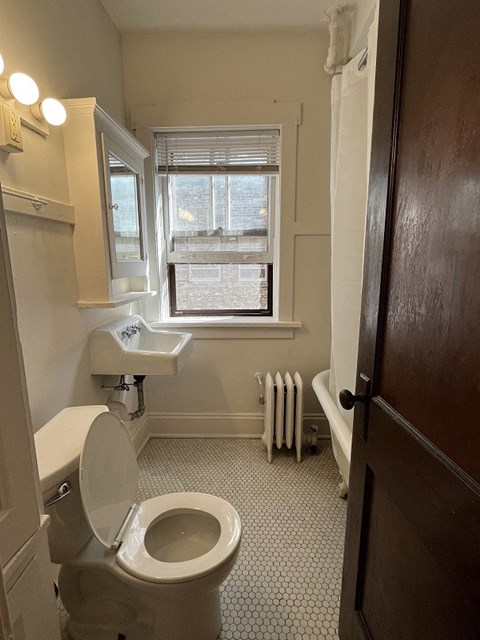 a bathroom with a toilet and a sink and a window