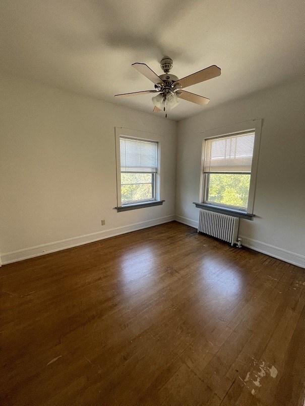 an empty living room with a ceiling fan and a window