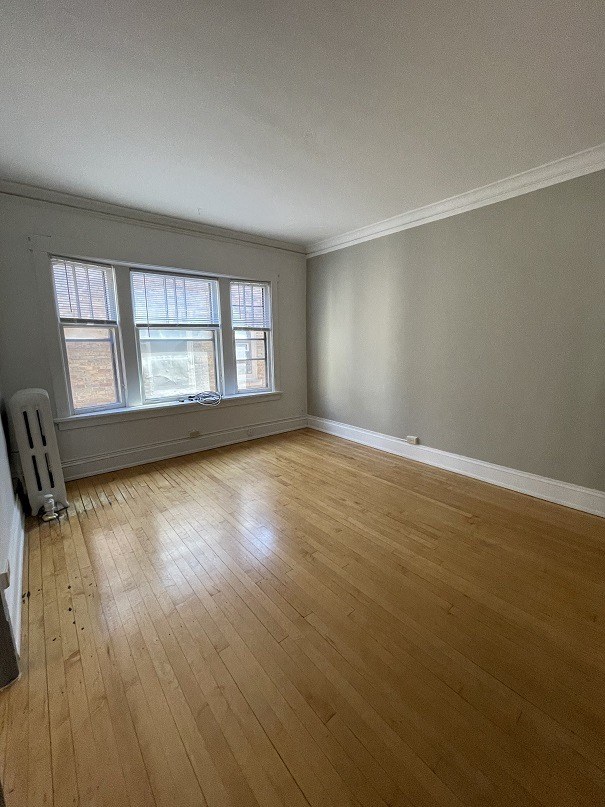 an empty living room with wood floors and a window