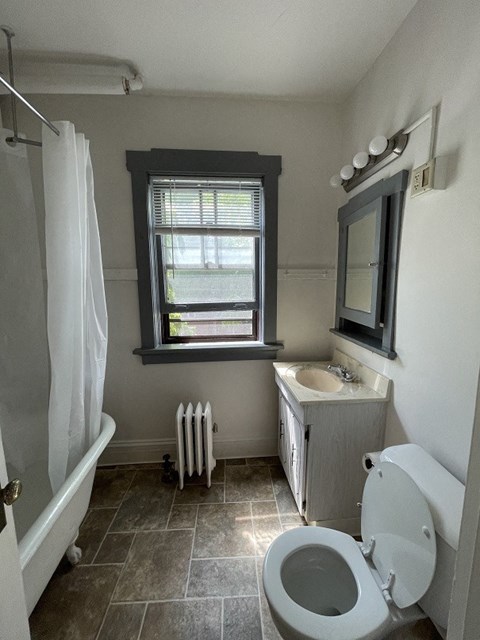 a bathroom with a toilet and a sink and a window