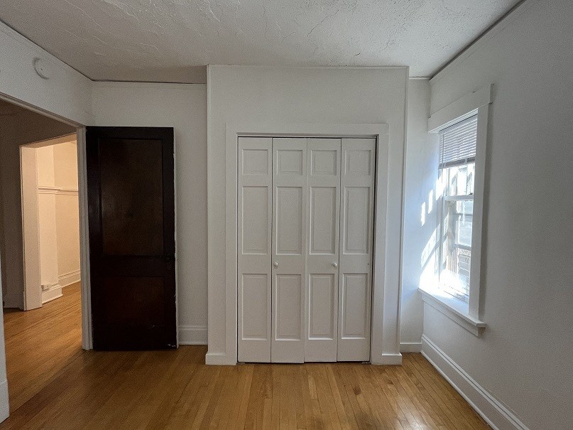 the living room of an empty house with white walls and a door